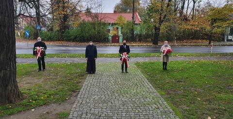 Na zdjęciu czteroosobowa delegacja gminna z wiązankami kwiatów. 