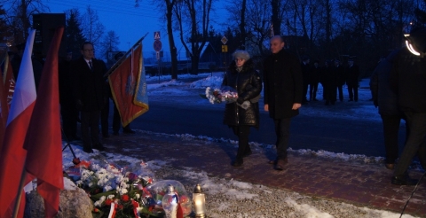 Uroczystość 103. rocznicy wybuchu Powstania Wielkopolskiego pod tablicą pamiątkową na skwerze przy ul. Powstańców Wielkopolskich. Na zdjęciu dwuosobowa delegacja składa kwiaty pod tablicą.