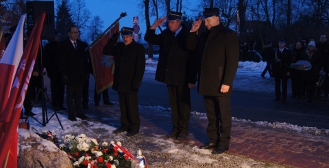 Uroczystość 103. rocznicy wybuchu Powstania Wielkopolskiego pod tablicą pamiątkową na skwerze przy ul. Powstańców Wielkopolskich. Na zdjęciu trzyosobowa delegacja strażaków przed tablicą.