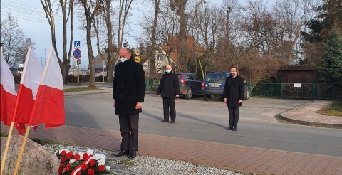 Na zdjęciu Sołtys z Gminy Duszniki składający wiązankę kwiatów pod pamiątkową tablicą.