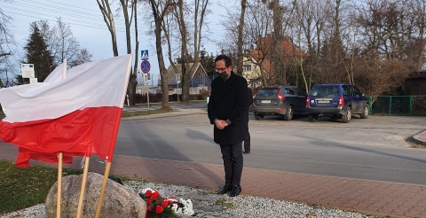 Na zdjęciu Wójt Gminy Duszniki składający wiązankę kwiatów pod tablicą pamiątkową.