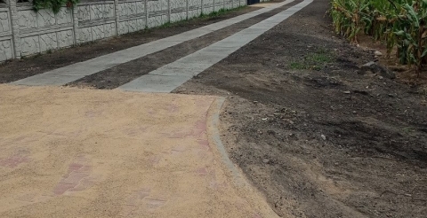 Na zdjęciu droga do świetlicy wiejskiej w Chełminku wykonana z płyt betonowych i wjazdem z kostki brukowej.