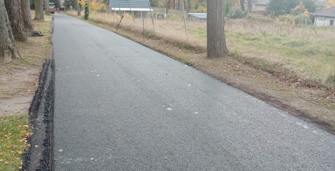 Wyremontowana droga w Sędzinach z nową nawierzchnią z betonu asfaltowego.