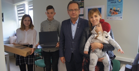 Uczniowie z nowymi laptopami w towarzystwie wójta Romana Bogusia i rodziny.