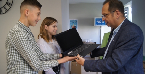 Wójt Roman Boguś przekazuje sprzęt uczniom z terenu gminy.