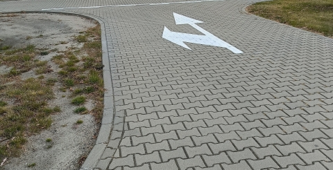 Znaki poziome na drodze wewnętrznej przy szkole i sali sportowej w Dusznikach