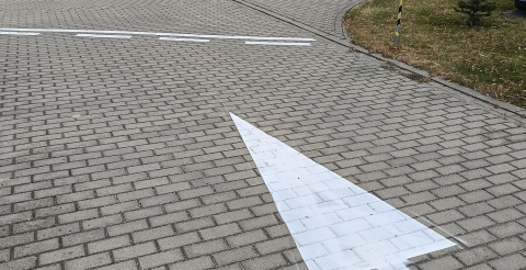 Znaki poziome na drodze wewnętrznej przy szkole i sali sportowej w Dusznikach