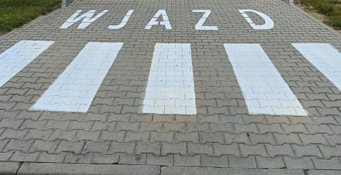 Znaki poziome na drodze wewnętrznej przy szkole i sali sportowej w Dusznikach