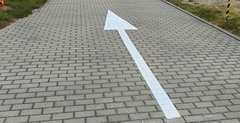 Znaki poziome na drodze wewnętrznej przy szkole i sali sportowej w Dusznikach