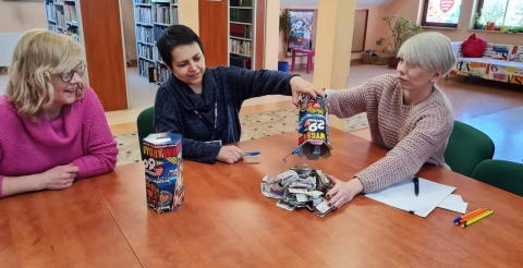 Na zdjęciu wolontariusze oddają członkini Sztabu do przeliczenia zebrane pieniądze do puszek