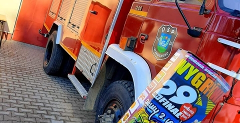 Na zdjęciu puszka WOŚP na tle wozu strażackiego