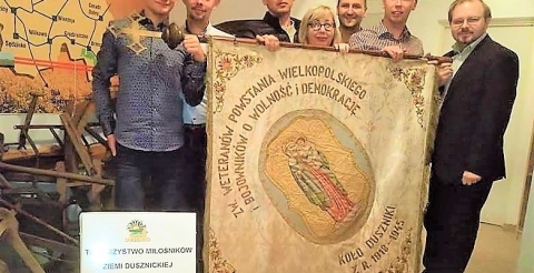 Członkowie Koła z zabytkowym sztandarem, wypożyczonym z Muzeum Zamek Gorków 