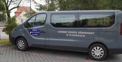 Samochód służbowy z naklejką konkursu na parkingu przed urzędem