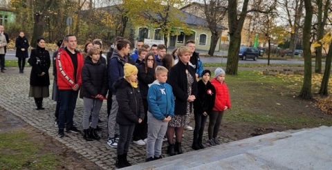 Delegacja szkoły podstawowej przed pomnikiem. 