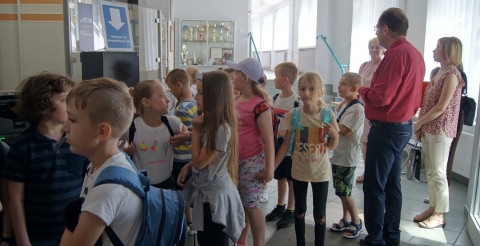Uczniowie klasy Ic ze Szkoły Podstawowej w Dusznikach z wójtem, wychowawcą i opiekunkami w holu urzędu gminy.