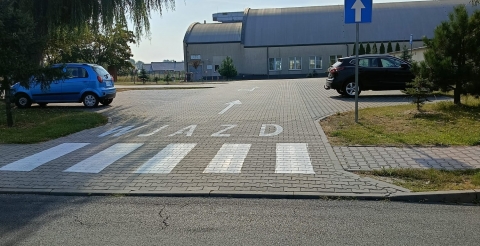 Znaki poziome i pionowe na drodze wewnętrznej przy szkole i sali sportowej w Dusznikach