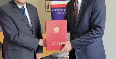 Na zdjęciu uścisk rąk Wójta Gminy Duszniki (z lewej) i Wojewody Wielkopolskiego (z prawej).  Wojewoda trzyma teczkę z podpisaną umową.
Zdjęcie ze strony Wielkopolskiego Urzędu Wojewódzkiego: https://www.poznan.uw.gov.pl/wydarzenia-biezace/rzadowe-wsparcie-inwestycji-drogowych-w-polnocnej-wielkopolsce